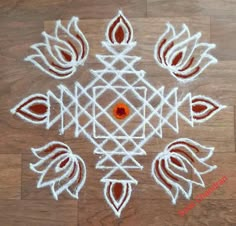 a white and red design on a wooden floor with some orange dots in the middle