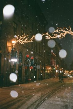 a snowy street at night with christmas lights