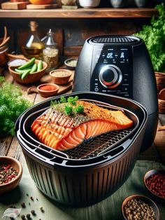 salmon being cooked in an air fryer with spices and herbs around it on a wooden table