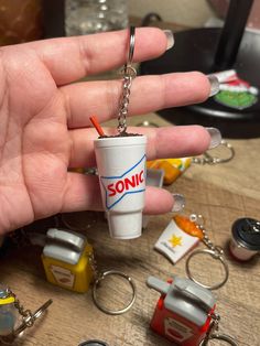 a hand holding a cup shaped keychain with the word sonic on it