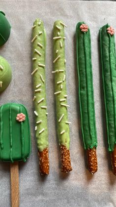 four green desserts are arranged on a sheet of wax paper, with cactus decorations