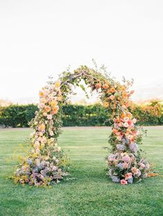 an outdoor ceremony setup with flowers and greenery