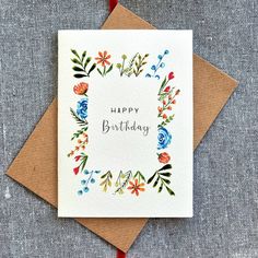 a card with the words happy birthday written on it and colorful flowers in a square frame