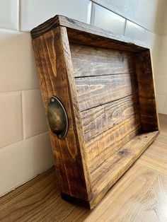 a wooden box sitting on top of a hard wood floor next to a tile wall