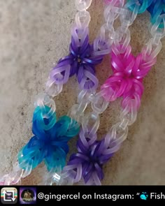 three plastic flowers are on the ground next to each other and one is purple, blue, and pink