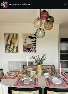 a dining room table with plates and bowls on it