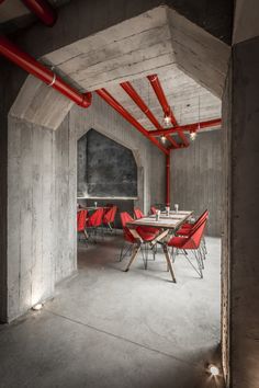 an empty room with red chairs and tables