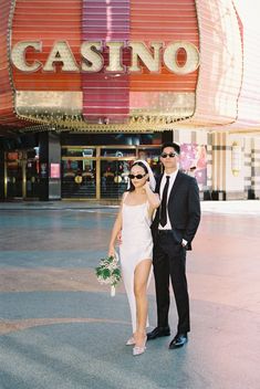 a man and woman standing in front of a casino