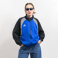 Vintage 90's Adidas track jacket with a front zip - in blue-black with white stripes - embroidered logo on the chest and on the back - 2 outer pockets with zipper closure - materials: polyester SIZE from the tag: USA M, D 6, GB 40/42", F 180 Best fits women: L MEASUREMENTS width from armpit to armpit: 24 inches (61 cm) length: 27 inches (68 cm) sleeve length from the neck: 29 inches (74 cm) The model is 5'9" (174 cm), measures 35-27-38 (89-69-96 cm) and typically wears clothing in size M CONDITI Blue Sporty Track Jacket For College, Blue Sporty Track Jacket For Streetwear, Blue Athleisure Outerwear With Three Stripes, Adidas Logo Winter Track Jacket For Sports Events, Three Stripes Track Jacket For Sports Events, Sporty Adidas Track Jacket For Sports Events, Winter Streetwear Track Jacket With Contrast Stripes, Sportswear Track Jacket With Zipper For Streetwear, Blue Three Stripes Track Jacket For Fall