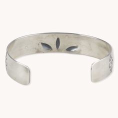 a silver bracelet with two leaves on it