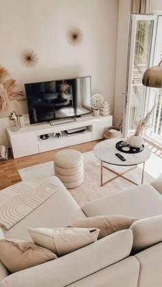 a living room filled with furniture and a flat screen tv on top of a wooden floor