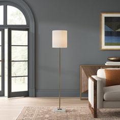 a living room with grey walls and a gold floor lamp