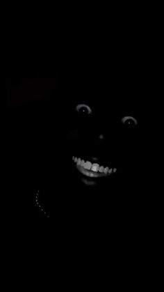 a black and white photo of a person's face in the dark with eyes wide open