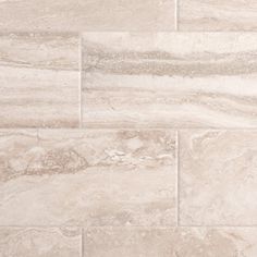 a close up view of a tile floor with white and gray colors on it,