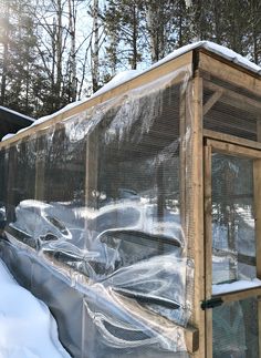 a wooden structure covered with plastic in the snow