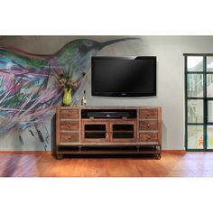 a bird painted on the wall next to a large screen tv in a living room