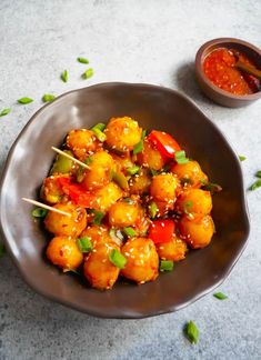 a brown bowl filled with food and chopsticks on top of a table next to another bowl