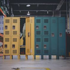 several lockers are lined up in an empty room with yellow and blue doors on each side