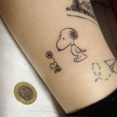 a small tattoo on the arm of a person with a dog and flowers around it