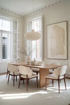 an elegant dining room with white chairs and a wooden table