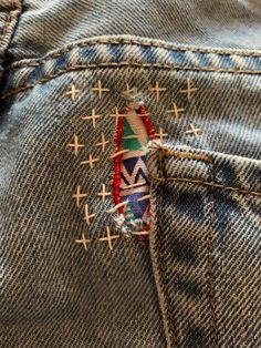 a patch in the back pocket of a pair of blue jeans with crosses on it