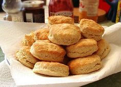 a pile of biscuits sitting on top of a white paper towel in front of some condiments