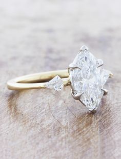 a diamond ring sitting on top of a wooden table