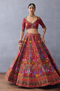 Red attached cancan lehenga with floral print and side pompom tasseles. Paired with a floral print blouse with a heart cutout tasseled back and cutwork embroidered tasseled dupatta. - Aza Fashions Bohemian Red Lehenga For Festive Occasions, Red Choli With Motifs For Navratri, Red Floral Embroidered Lehenga For Diwali, Red Lehenga With Motifs For Navratri, Red Bohemian Lehenga With Traditional Drape, Red Floral Embroidery Lehenga For Diwali, Festive Bohemian Red Lehenga, Red Fitted Bohemian Sharara, Bohemian Red Lehenga For Party