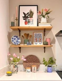 the kitchen is decorated with pots, plates and vases on the shelves above the stove