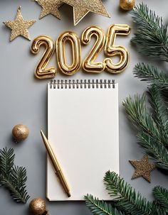 a notepad with the number 2055 on it next to christmas decorations and gold stars