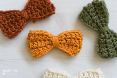 four crocheted bow ties laid out on a table