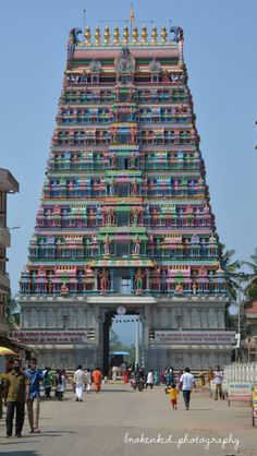 a very tall colorful building with people walking around it