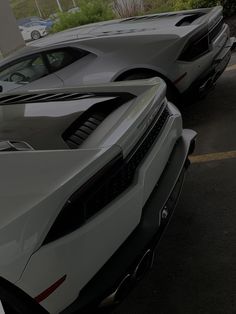 two white sports cars parked next to each other