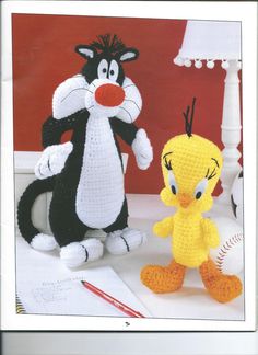 two crocheted stuffed animals sitting next to each other in front of a lamp