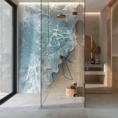 a glass walled shower in a bathroom next to a window with ocean waves on it