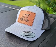 Tailing redfish trucker hat is perfect for anyone that appreciates redfish. Whether you are chasing red drum in the Carolinas, Florida, Texas or somewhere else, this beautiful laser engraved patch hat is sure to be appreciated by anyone chasing the prized fish. Item Details: Hat:  * 65% polyester, 35% cotton * 6-panel, structured, hard buckram backed front panels * Matching undervisor * 8-row stitching on visor * 3 1/2" mid-profile crown * Matching snapback closure Patch: * 3.5" x 2.5" leatherette adhered to hat * Resists water spots * Cleans easily * Durable Adjustable Trucker Hat For Fishing, Adjustable Curved Brim Trucker Hat For Fishing, Adjustable Curved Bill Hat For Fishing, Trucker Hat For Fishing With Flat Bill, Curved Brim Trucker Hat For Fishing, Trucker Hat With Flat Bill For Fishing, Trucker Baseball Cap For Fishing With Curved Bill, Fishing Trucker Cap With Curved Bill, Trucker Baseball Cap With Curved Brim For Fishing