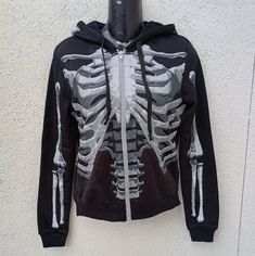 The Black & Bone Hoodie For Adults Gives New Meaning To The Term "The Walking Dead!" This Long-Sleeve Black Sweatshirt Features A Detailed X-Ray Skeleton Print On The Front And Back, Including Skull Profiles On Either Side Of The Hood. Rock This Spooky Look On Halloween Or Every Day Brand Black And Bone Item Skeleton Hoodie Size One Size Fits Most Fits Like A Small Measurements Pictured Not Responsible For Fit Or Size Condition New With Tags And Packaging Items Can Contain Unseen Flaws Please Se Winter Skull Print Grunge Outerwear, Halloween Black Skull Print Outerwear, Halloween Black Outerwear With Skull Print, Winter Skull Print Hoodie Outerwear, Hooded Halloween Costume Outerwear, Halloween Hooded Outerwear With Skull Print, Alternative Halloween Costume Outerwear, Grunge Hooded Outerwear For Halloween, Hooded Grunge Outerwear For Halloween