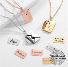 four necklaces with different types of letters on them and one has an envelope in the middle