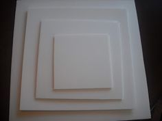 three square white plates sitting next to each other on top of a black countertop