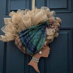 a mannequin's head is adorned with burlap and yarns