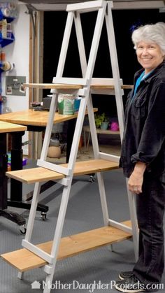 an older woman standing next to a wooden ladder