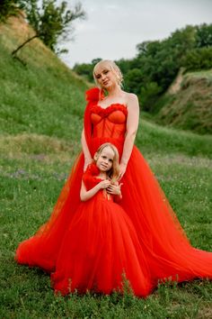 mother and daughter in red dresses posing for the camera