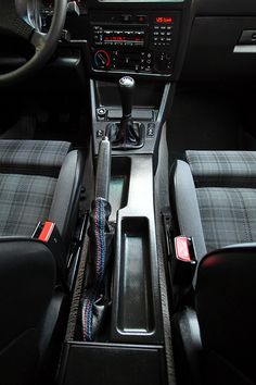 the interior of a car with black and gray seats, dash board, steering wheel and dashboard controls