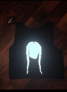 a black vest with a white light on it and a long braid in the back