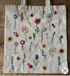 a white bag with embroidered flowers on it