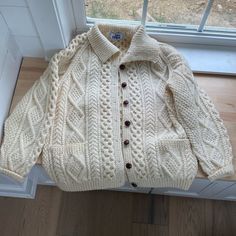 Cream Color Fisherman Cable-Knit Button-Down Cardigan Sweater With Collar And Front Patch Pockets. Raglan Sleeves. Thick, Heavyweight, And Very Warm. Pure New Wool, Itchy Material. It’s Unused And In Pristine Condition. Has A Slight Vintage Odor Due To Its Age. One Size - Could Fit Up To An Xxl - Please Check Measurements Below To Determine Fit. Approx Flat- Pit To Pit 24” Length 27.5” Sleeve Length 30” White Cable Knit Button-up Outerwear, White Knitted Button-up Outerwear, Cream Sweater Coat With Button Closure And Long Sleeves, Cream Sweater Coat With Button Closure, Cream Long Sleeve Cardigan With Buttons, White Wool Outerwear With Buttons, Cream Long Sleeve Sweater Coat With Buttons, Classic Beige Chunky Knit Outerwear, White Cable Knit Long Sleeve Polo Sweater