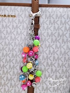 a handbag with a bunch of colorful beads hanging from it's front pocket