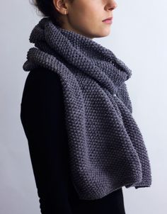 a woman wearing a gray knitted scarf