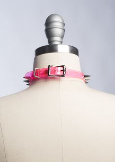 Classic choker collar with a colorful twist. Silver 1/2" spikes riveted evenly throughout. Adjustable buckle in back. Available in PVC, leather, or vegan leather. An essential item for any goth or punk who likes a little bit of color, festival or clubkids-inspired looks. Collar is 1/2" wide. Shown in neon pink PVC. Silver-toned nickle plated steel hardware. Neon pink and neon orange PVC are UV/Blacklight reactive. SMALL/MEDIUM (11-13")MEDIUM/LARGE (13-15")LARGE/X-LARGE (15-17") Custom sizing ava Gothic Spiked Choker For Festivals, Edgy Adjustable Choker For Party, Adjustable Edgy Party Choker, Party Choker With Spikes, Punk Spiked Choker For Parties, Punk Spikes Choker For Party, Adjustable Punk Choker For Alternative Fashion, Adjustable Alternative Style Party Choker, Edgy Spiked Choker For Party