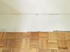 an empty room with hard wood flooring and white paint on the wall above it